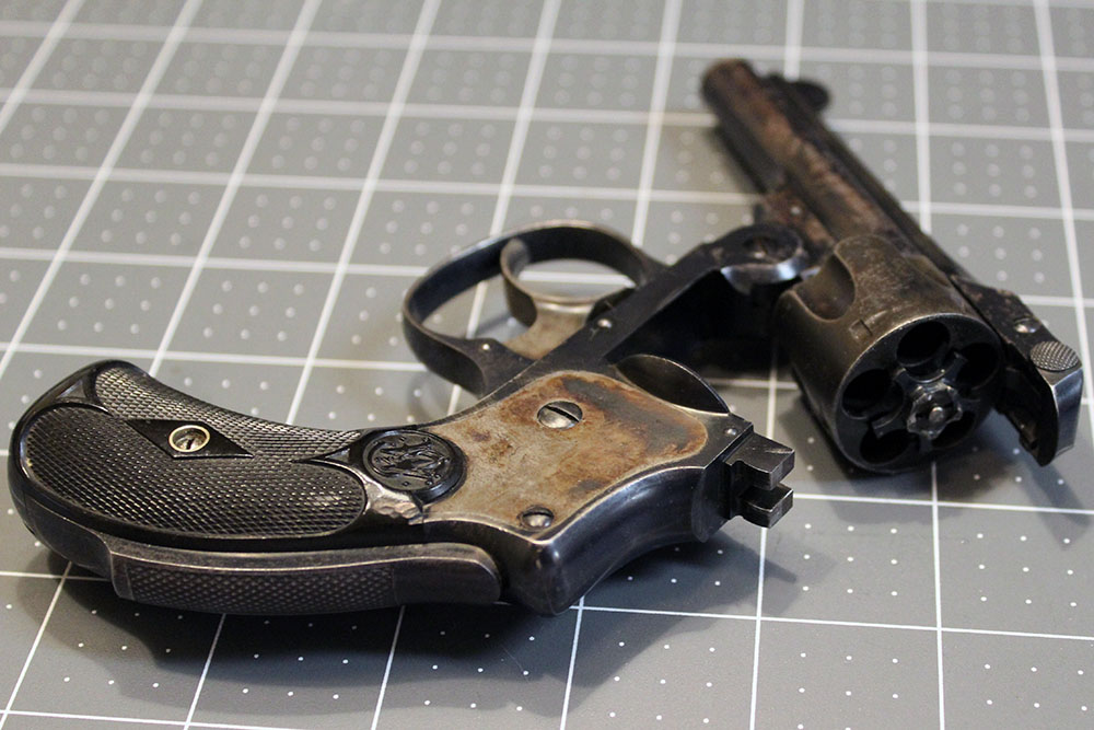 Safety Hammerless revolver, partly open, lying on table